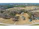 Expansive aerial view of a property featuring a well-maintained home, outbuildings, and surrounding woodlands at 1304 Nc 96 Hwy S, Zebulon, NC 27597