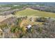 Aerial view of expansive property featuring multiple homes and buildings nestled in a mix of woodlands and farmland at 1304 Nc 96 Hwy S, Zebulon, NC 27597