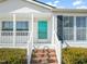 Inviting front porch with brick steps, white railing, and a charming turquoise door at 1304 Nc 96 Hwy S, Zebulon, NC 27597