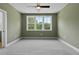 Bright bedroom featuring soft grey carpet, a modern ceiling fan, and three large windows at 136 E End Ave # 4, Durham, NC 27703