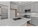 Elegant kitchen featuring gray cabinets, stainless steel appliances, and a spacious island with sink at 136 E End Ave # 4, Durham, NC 27703