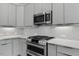 Contemporary kitchen features stainless steel oven, microwave, gray cabinetry and white countertops at 136 E End Ave # 4, Durham, NC 27703