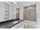 A modern bathroom features gray tile, a new vanity with a black countertop and a bathtub at 140 E End Ave # 2, Durham, NC 27703