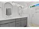 Modern bathroom featuring double sinks, sleek gray cabinetry, and a tiled walk-in shower at 140 E End Ave # 2, Durham, NC 27703