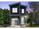 A modern two-story home features a gray exterior, a light blue front door and an attached garage at 140 E End Ave # 2, Durham, NC 27703