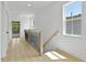A hallway features light hardwood floors, a wood and metal railing and a window with natural light at 140 E End Ave # 2, Durham, NC 27703