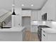 Open kitchen with island, white cabinets, and stainless steel appliances at 140 E End Ave # 2, Durham, NC 27703