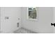 A light-filled laundry room features hexagon tile and a large window with views of the outdoors at 140 E End Ave # 2, Durham, NC 27703
