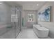 Luxurious bathroom featuring a soaking tub, a spacious glass-enclosed shower, and marble tile at 1400 Gathering Park Cir # 202, Cary, NC 27519