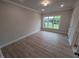 A bright bedroom features wood floors and a large window with neighborhood views at 1400 Gathering Park Cir # 202, Cary, NC 27519