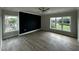 Large bedroom with wood-look floors, a dark accent wall, and large windows at 1400 Gathering Park Cir # 202, Cary, NC 27519