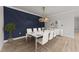 Modern dining room featuring white furniture, stylish chandelier, and a striking blue accent wall at 1400 Gathering Park Cir # 202, Cary, NC 27519