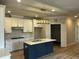 Open kitchen with stainless appliances, white cabinets, and a dark island at 1400 Gathering Park Cir # 202, Cary, NC 27519