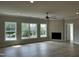 Spacious living room featuring three large windows, ceiling fan, and modern flooring at 1400 Gathering Park Cir # 202, Cary, NC 27519