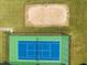Overhead view of a green and blue tennis court and sand volleyball court surrounded by green grass at 1400 Gathering Park Cir # 202, Cary, NC 27519