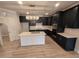 Modern kitchen with black cabinets, quartz countertops, stainless steel appliances, and pendant lighting at 1400 Gathering Park Cir # 204, Cary, NC 27519