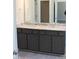 Bathroom vanity with double sinks, light countertops, and dark wood-look cabinets at 1415 Reading Ct # 77Kl, Burlington, NC 27217