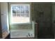 A luxurious soaking tub and a tiled glass shower are the focal point of this Primary bathroom at 1415 Reading Ct # 77Kl, Burlington, NC 27217