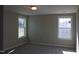 Bright bedroom featuring neutral walls, plush carpeting, and two large windows at 1415 Reading Ct # 77Kl, Burlington, NC 27217