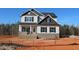 New construction two-story home showing light siding, a brick foundation, and black trim under a bright blue sky at 1415 Reading Ct # 77Kl, Burlington, NC 27217