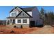 New construction two-story home with light siding, a brick foundation, black trim, and a two-car garage at 1415 Reading Ct # 77Kl, Burlington, NC 27217