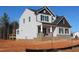 New construction two-story home with light siding, a brick foundation, black trim, and a screened-in back porch at 1415 Reading Ct # 77Kl, Burlington, NC 27217