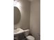 A powder room featuring a toilet, a small white sink, and an oval mirror at 1415 Reading Ct # 77Kl, Burlington, NC 27217