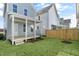 View of the backyard featuring grass, a small deck, and a wooden fence at 1662 Piney Fls Dr, Wendell, NC 27591