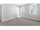 A modern bedroom featuring plush carpet, neutral walls, and double windows at 1662 Piney Fls Dr, Wendell, NC 27591