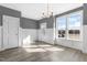 Airy dining room with natural light, light-gray walls, white wainscoting and an elegant light fixture at 1662 Piney Fls Dr, Wendell, NC 27591