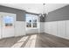 Inviting dining room with light-gray walls, white wainscoting, modern lighting, and wood-look floors at 1662 Piney Fls Dr, Wendell, NC 27591