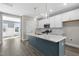 Bright kitchen with blue island, quartz countertops, pendant lighting, and stainless appliances at 1662 Piney Fls Dr, Wendell, NC 27591