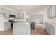 Well-lit kitchen with gray cabinets, stainless steel appliances, granite counters, and island at 1705 Post Oak Dr, Haw River, NC 27258