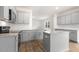 Open kitchen with island, modern appliances, granite countertops, and light gray cabinets at 1705 Post Oak Dr, Haw River, NC 27258