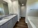 The well-lit bathroom features double sinks, granite countertops, gray cabinets, and luxury vinyl flooring at 181 Pate Landing Dr, Selma, NC 27576