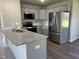 Modern kitchen features gray cabinets, stainless steel appliances, a granite countertop island, and vinyl flooring at 181 Pate Landing Dr, Selma, NC 27576