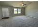 Spacious living room with plush carpeting, a ceiling fan, and natural light from a large window at 181 Pate Landing Dr, Selma, NC 27576