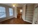 Inviting living room featuring hardwood floors, natural light, a ceiling fan, and a shelving unit at 1828 Parkside Village Dr, Clayton, NC 27520