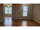 Bright living area featuring hardwood floors, with a ceiling fan and large windows for natural lighting at 1828 Parkside Village Dr, Clayton, NC 27520