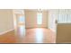 Open-concept living area with hardwood floors, neutral walls, and lots of natural light from large windows at 1828 Parkside Village Dr, Clayton, NC 27520