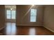 Bright living room featuring hardwood floors and an abundance of natural light from large windows at 1828 Parkside Village Dr, Clayton, NC 27520