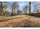 Expansive backyard with mature trees, a wooden fence, and plenty of room to entertain at 209 James St, Apex, NC 27502