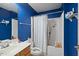 Bright blue bathroom featuring a shower/tub combo and a white vanity with ample storage at 209 James St, Apex, NC 27502