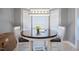 Charming dining area with a round wood table, white chairs, and a modern light fixture at 209 James St, Apex, NC 27502