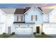 Charming townhome featuring a two-car garage, neutral siding, and a warm, inviting entrance at 3406 Pelican Ln, Durham, NC 27703