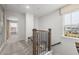 Hallway with carpet, wooden railing, and a sitting bench by a large window at 3406 Pelican Ln, Durham, NC 27703