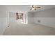 Spacious bedroom featuring neutral carpet, wood paneling, a ceiling fan, and bright natural light at 4041 Wendy Ln, Zebulon, NC 27597