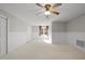 Spacious bedroom featuring neutral carpet, wood paneling, a ceiling fan, and bright natural light at 4041 Wendy Ln, Zebulon, NC 27597