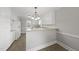 Well-lit kitchen featuring tile floors, white cabinetry, modern fixtures, and a convenient breakfast bar at 4041 Wendy Ln, Zebulon, NC 27597