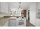Bright kitchen featuring tile floors, white cabinets, modern stove and breakfast bar overlooking fireplace at 4041 Wendy Ln, Zebulon, NC 27597